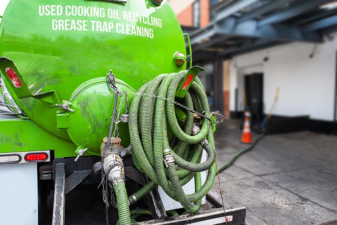 a grease trap being pumped by a sanitation technician in Chautauqua